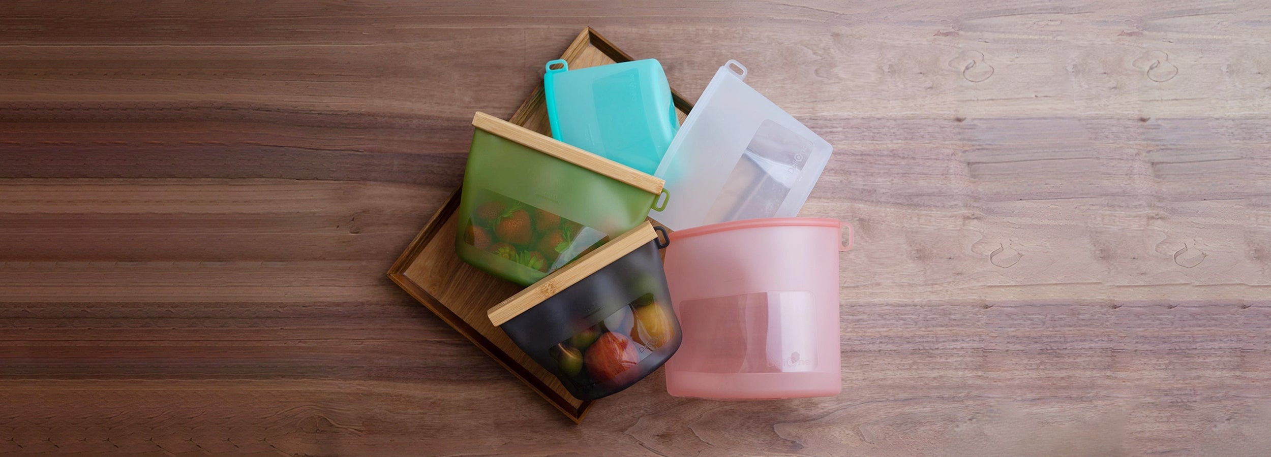 DeliOne silicone food storage containers and stretch lids on a neutral kitchen surface